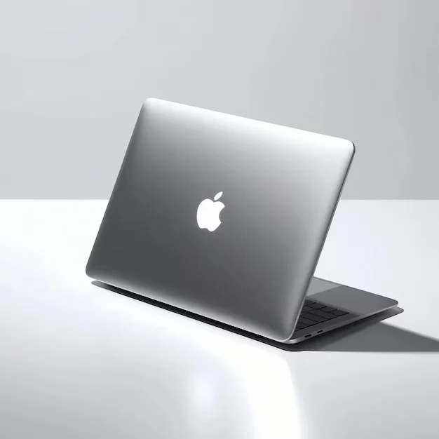 apple laptop is open sitting white table